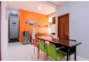 an orange kitchen with a dining table and chairs at Embe Enem Homestay in Yogyakarta