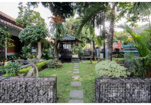 a garden with a walkway in front of a house at Embe Enem Homestay in Yogyakarta