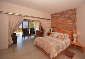 a bedroom with a bed and a brick wall at IRONWOOD LODGE in Pennington