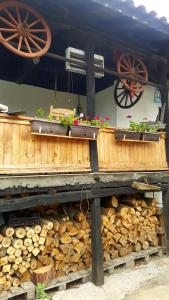 ein Holztisch mit einem Stapel Brennholz und zwei Wagenrädern in der Unterkunft Събевата къща in Sinʼo Bŭrdo