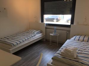 niewielka sypialnia z 2 łóżkami i oknem w obiekcie Zimmer nahe Messe und Flughafen w mieście Düsseldorf