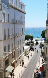 - un bâtiment dans une rue à côté de l'océan dans l'établissement Azurene Royal Hotel, à Cannes