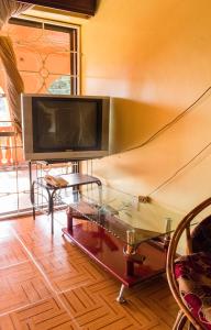 a living room with a tv and a glass table at Sydney Hotel Kampala in Kampala