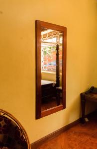 a mirror on a wall in a room at Sydney Hotel Kampala in Kampala