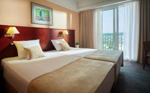 duas camas num quarto de hotel com uma grande janela em Grand Hotel Portoroz 4* superior – Terme & Wellness LifeClass em Portorož