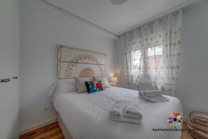 1 dormitorio con 1 cama con 2 zapatillas en Edificio Aptos Turisticos - Burgos Centro HC7, en Burgos