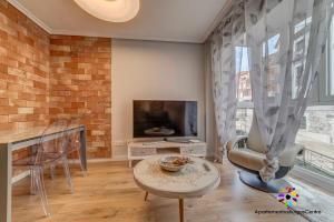 a living room with a table and a tv at Edificio Aptos Turisticos - Burgos Centro HC7 in Burgos