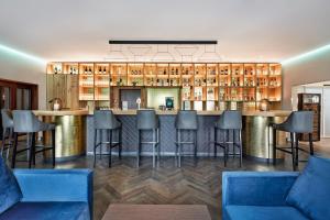 a bar in a restaurant with blue bar stools at H+ Hotel Frankfurt Airport West in Hofheim am Taunus