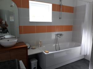 La salle de bains est pourvue d'une baignoire et d'un lavabo. dans l'établissement Landrichamps, à Landrichamps