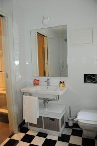 ein Badezimmer mit einem Waschbecken, einem WC und einem Spiegel in der Unterkunft Alma Mater B&B in Rom