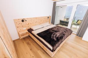 een slaapkamer met een bed en een groot raam bij Baumgartnerhof MÜLLER THURGAU in Cortaccia