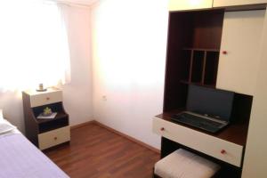 a bedroom with a desk with a laptop on it at Apartmani Marija in Grebaštica