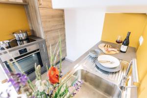 een kleine keuken met een wastafel en een fornuis bij Baumgartnerhof MÜLLER THURGAU in Cortaccia