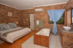 a bedroom with a bed and a sink and a tub at IRONWOOD LODGE in Pennington