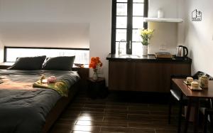 um quarto com uma cama, uma secretária e uma janela em Chaca House em Da Nang