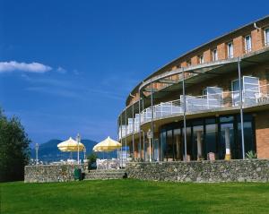 een gebouw met tafels en parasols ervoor bij Hotel Riu Fluviá in Olot