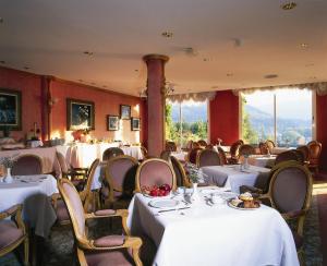 a dining room with tables and chairs with white tablecloths at Hotel Riu Fluviá in Olot
