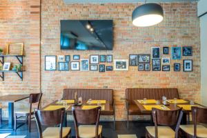 a brick wall with tables and chairs in a restaurant at Hotel Bologna in Prague