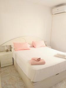 カルデス・デストラックにあるCaldes D'Estracのベッドルーム1室(ピンクのタオルが付いた白いベッド1台付)