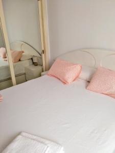カルデス・デストラックにあるCaldes D'Estracの白いベッド(鏡の前にピンクの枕付)