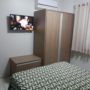 1 dormitorio con 1 cama y TV en la pared en Riviera Park Maria Bonita, en Caldas Novas