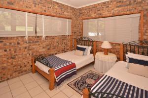 a bedroom with two beds and a brick wall at IRONWOOD LODGE in Pennington