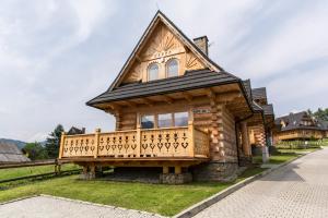 una cabaña de madera con techo de gambrel en TatryTop Świerkowa Chata en Kościelisko