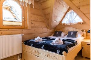 - une chambre avec un lit dans une cabane en rondins dans l'établissement TatryTop Świerkowa Chata, à Kościelisko