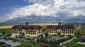 an aerial view of a large building with mountains in the background at APARTMAN LINDA - VEĽKÁ LOMNICA in Veľká Lomnica