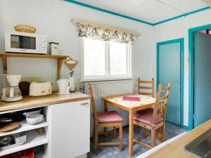 a kitchen with a table and a small table and chairs at 8 person holiday home in S LEN in Lindvallen