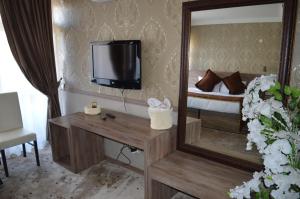 a room with a mirror and a tv and a bed at Nobel Hotel Ankara in Ankara