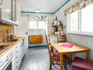 a kitchen with a wooden table and a dining room at 8 person holiday home in S LEN in Lindvallen