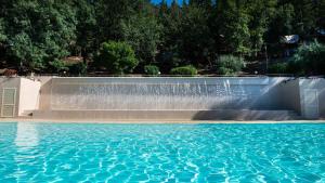 a pool of water with a fountain in the middle of it at Vallicella Glamping Resort in Scarlino