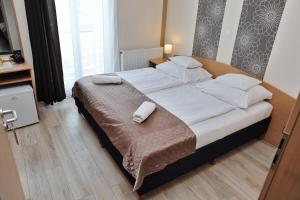 a bedroom with a bed and a dresser at Hotel Papillon in Budapest
