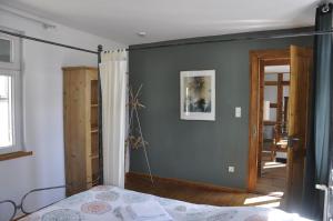 Un dormitorio con una pared gris y una cama en una habitación en Geibelhof en Karben