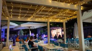 eine Gruppe von Menschen, die an Tischen in einem Restaurant sitzen in der Unterkunft Vallicella Glamping Resort in Scarlino