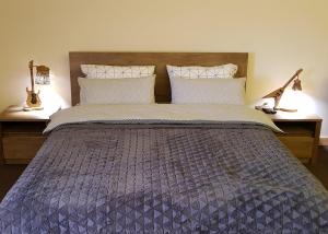 a bedroom with a large bed with two lamps at New Gudauri Suites in Gudauri