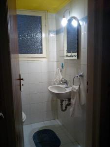 a bathroom with a sink and a toilet and a window at Detached House 120 sq.m., Kalamia Beach. in Korinthos