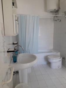 een witte badkamer met een wastafel en een toilet bij Sweet Home in Ischia