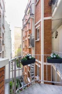 - un balcon avec deux plantes en pot dans un bâtiment dans l'établissement CMG Trocadéro / Doumer, à Paris