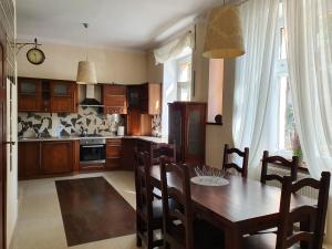 a kitchen with a wooden table and a dining room at APARTAMENT ADA in Kudowa-Zdrój