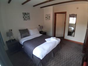 Habitación de hotel con cama grande y espejo en Bull Inn en Reading