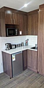 una cocina con armarios de madera y un aparato de acero inoxidable en Panorama Self Catering, en Panorama