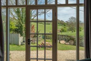 uma porta aberta com vista para um jardim visto através dela em The Garlic Farm em Sandown