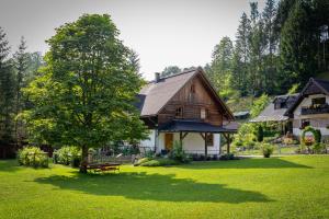 uma casa com uma árvore e um banco num quintal em Ferienhaus Göstling em Göstling an der Ybbs