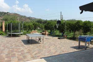 a ping pong table and a basketball hoop on a brick patio at Agriturismo Le Terre Di Zoe' in Limbadi