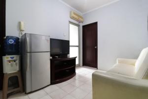 a living room with a refrigerator and a tv at Rent House Center at Apartement Mediterania Gajah Mada in Jakarta