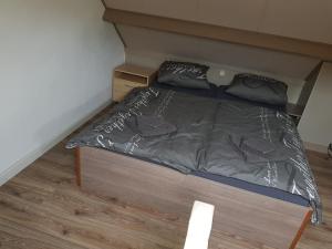 Ce lit se trouve dans une petite chambre dotée de parquet. dans l'établissement Brugman, à Egmond aan Zee