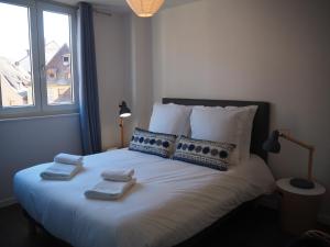 1 dormitorio con 1 cama grande y toallas. en L'Entêté CLIM HYPERCENTRE 5-7 personnes en Colmar