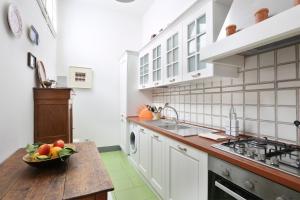 a kitchen with a bowl of fruit on a wooden table at Via della Chiesa Apartments in Florence